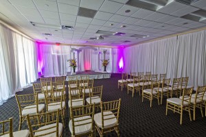 Live Oak Room at Red Oak Ballroom Austin is set for a Wedding Ceremony, perimeter drape, chivari chairs, small stage with columns