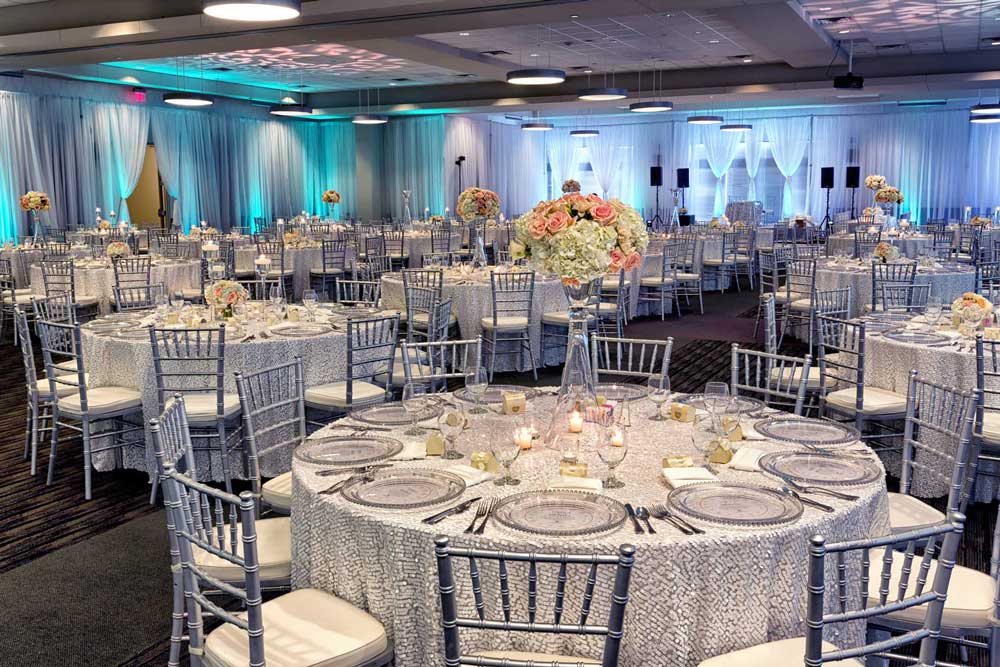 Red Oak Ballroom in Houston, CityCentre with silver bamboo chairs, table overlays, perimeter pipe and drape and uplighting