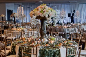 Ornate green Table Overlays with silver rimmed plate chargers, preset salads and gorgeous centerpieces at Red Oak Ballroom, Houston CityCentre