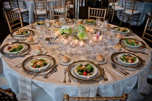 Elegant linens and bamboo chairs with silver rimmed plate chargers and preset salads at Red Oak Ballroom, Houston CityCentre