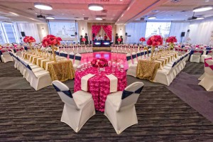 Red Oak Ballroom in Houston, CityCentre with covered chairs, table overlays, perimeter pipe and drape and uplighting