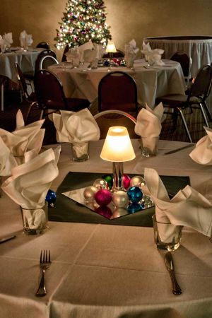 Festive and bright all white holiday party set with colorful balls as centerpiece